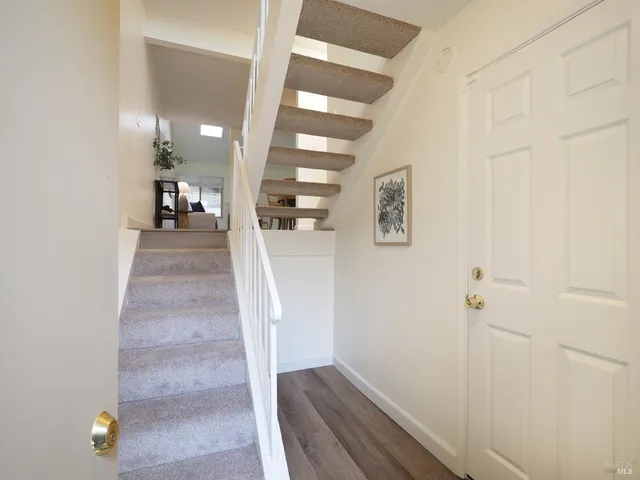 a view of a hallway with wooden floor and staircase