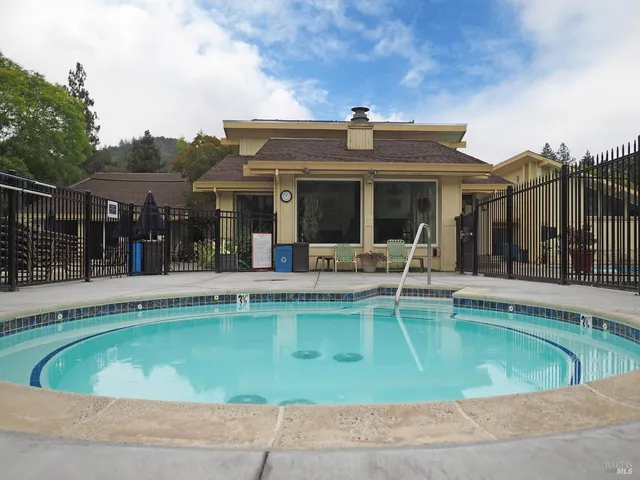 a view of a swimming pool with a bench in front of house