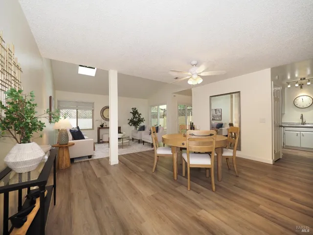 a dining room with wooden floor a chandelier a wooden table and chairs