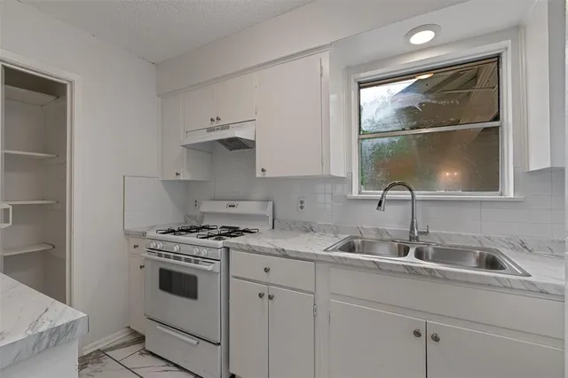 a kitchen with a sink stove and cabinets