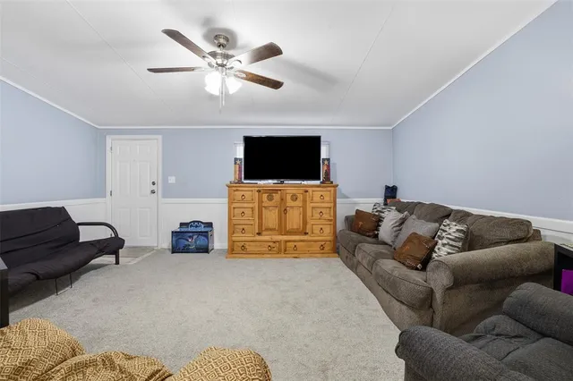 a room with dining table chairs and refrigerator
