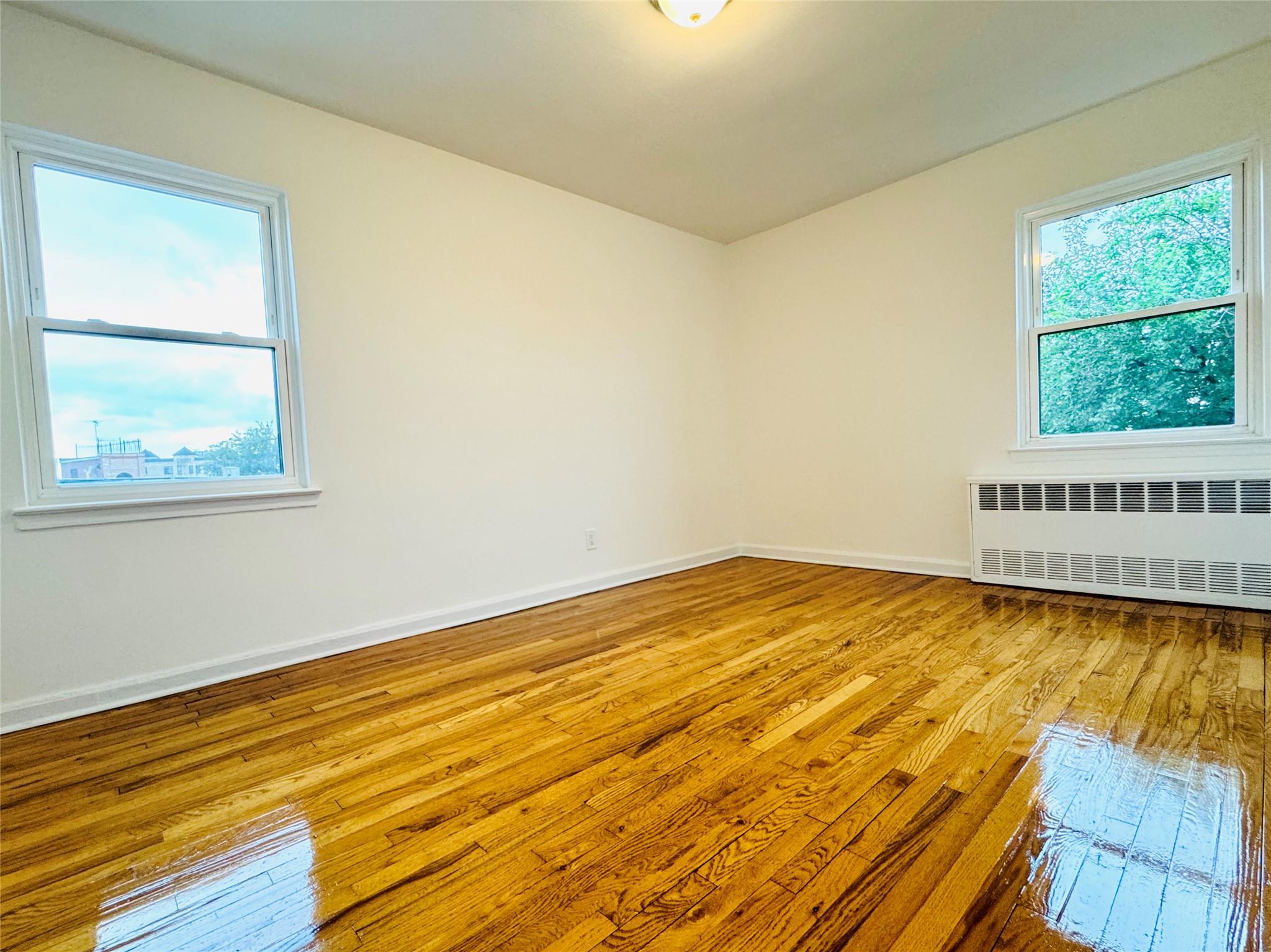 41-07 56th Street, Unit 3 Queens, NY 11377 - Photo 7 of 13 a view of empty room with wooden floor and fan