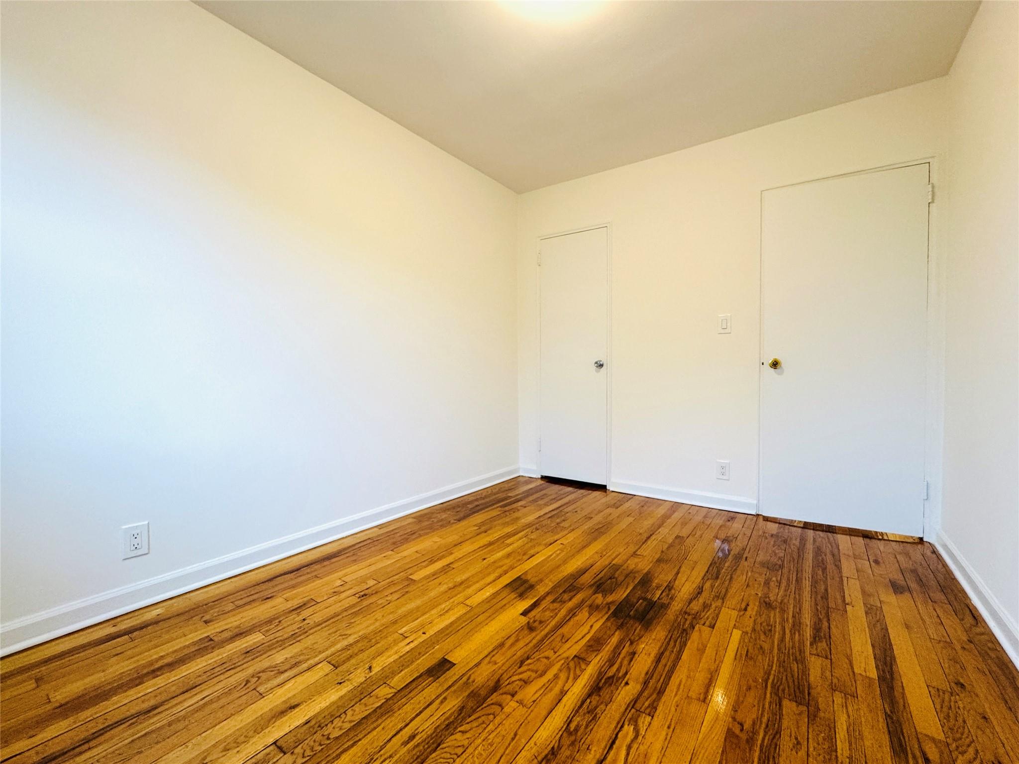 41-07 56th Street, Unit 3 Queens, NY 11377 - Photo 10 of 13 a view of empty room with wooden floor