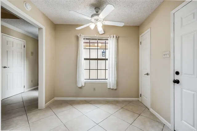 a view of an empty room with window and hardwood floor