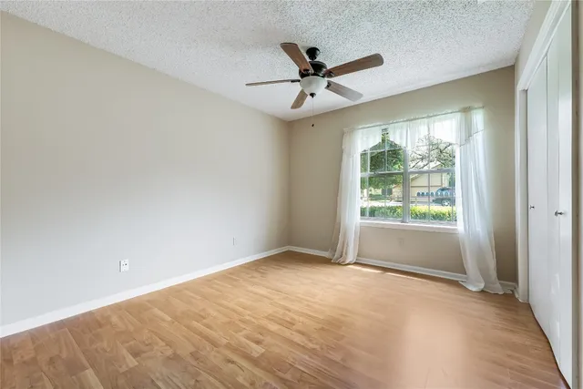 a view of a big room with wooden floor closet and windows
