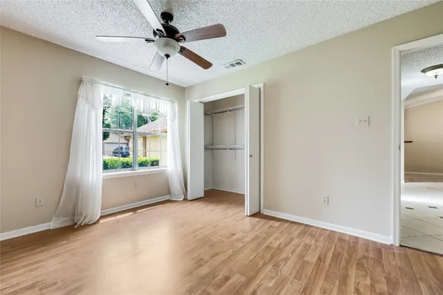 an empty room with fan and windows