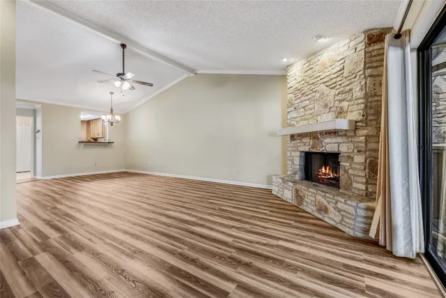a view of empty room with wooden floor and fireplace