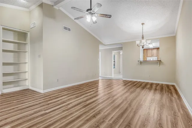 a view of empty room with wooden floor and ceiling fan