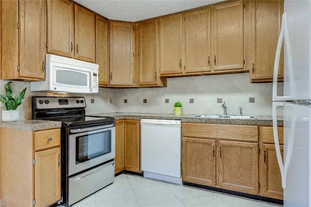 a kitchen with granite countertop cabinets stainless steel appliances and a sink