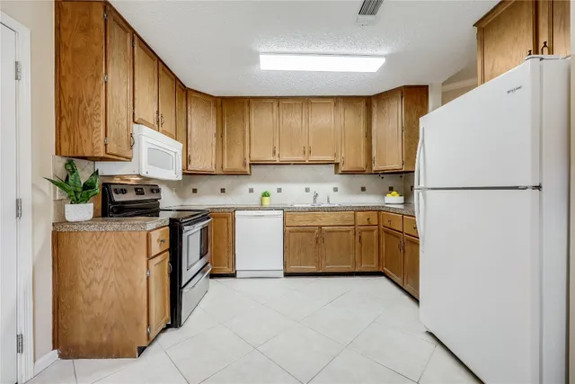 a kitchen with a refrigerator sink stove and cabinets
