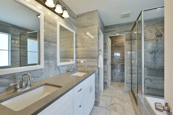 a spacious bathroom with a shower sink and mirror