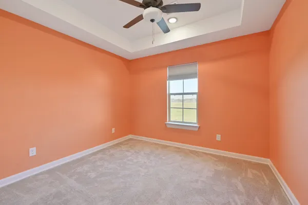 an empty room with a window and a ceiling fan