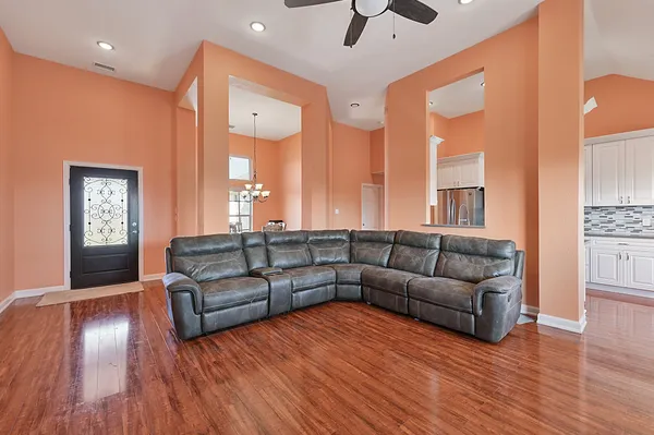 a living room with furniture and a wooden floor