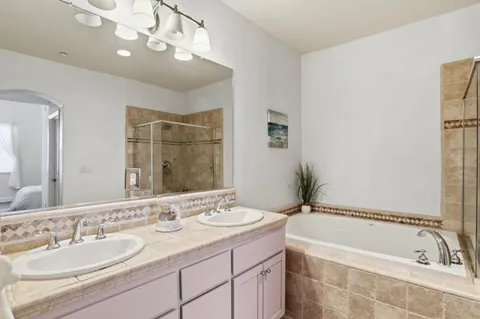 a bathroom with a tub a sink and mirror
