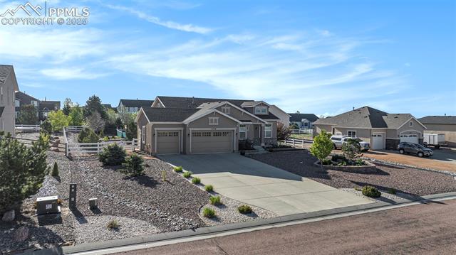 9709 Rockingham Drive Peyton, CO 80831 - Photo 46 of 50 View of front facade featuring a residential view, fence, a garage, and driveway