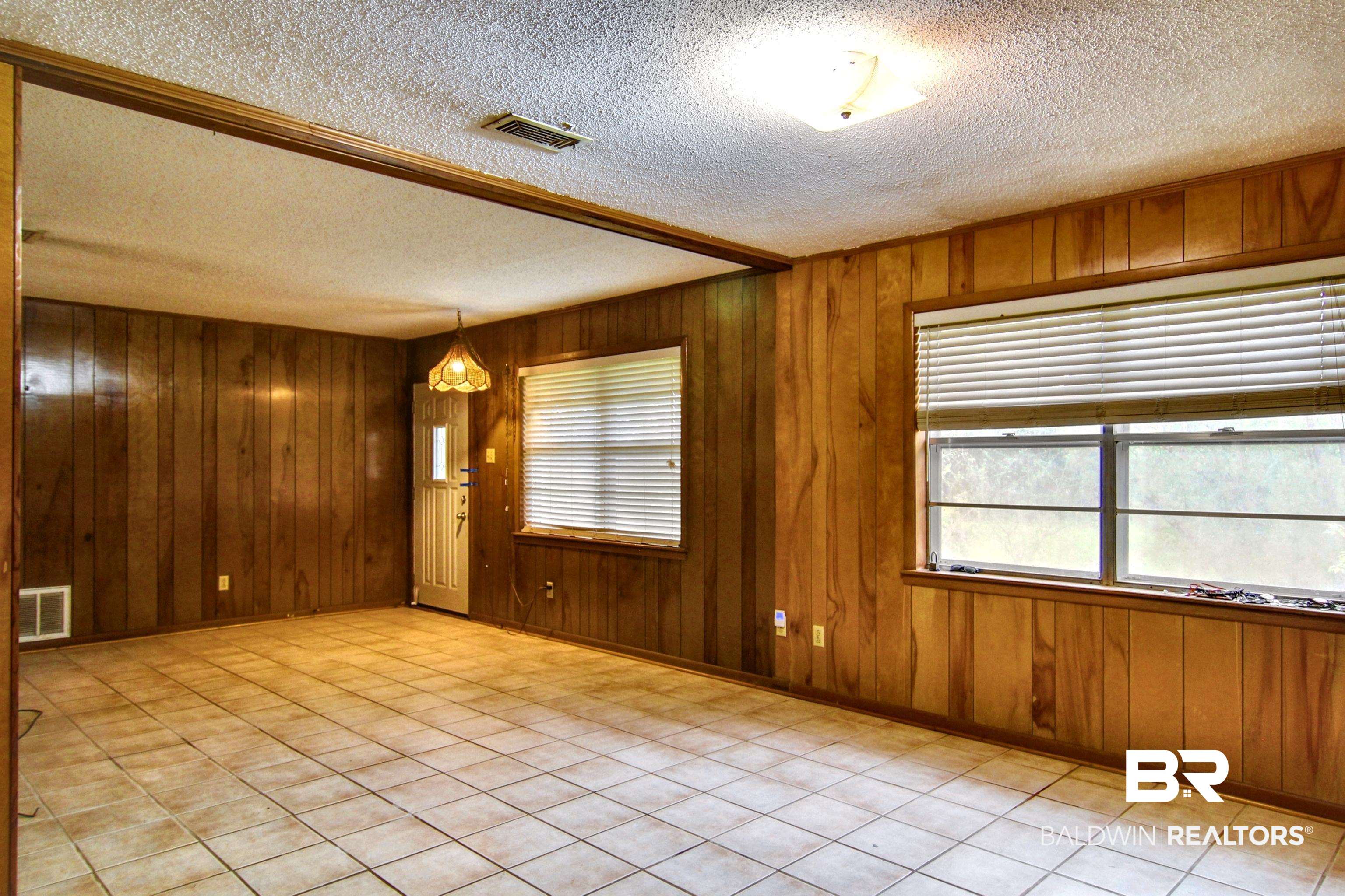 12897 County Road 65 Foley, AL 36535 - Photo 4 of 21 Empty room featuring a wealth of natural light, wood walls, and visible vents