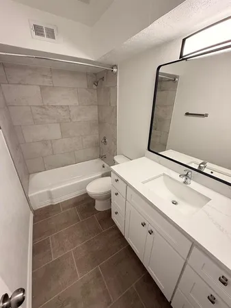 a bathroom with a double vanity sink toilet mirror and shower