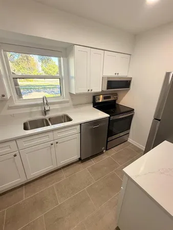 a kitchen with a sink cabinets and window