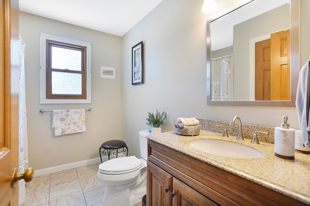 5 Flower Street Springfield, MA 01118 - Photo 31 of 42 a bathroom with a granite countertop sink a mirror and a toilet