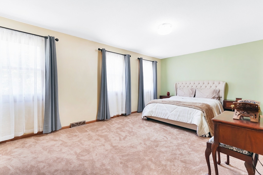 5 Flower Street Springfield, MA 01118 - Photo 38 of 42 a spacious bedroom with a bed and a table in it