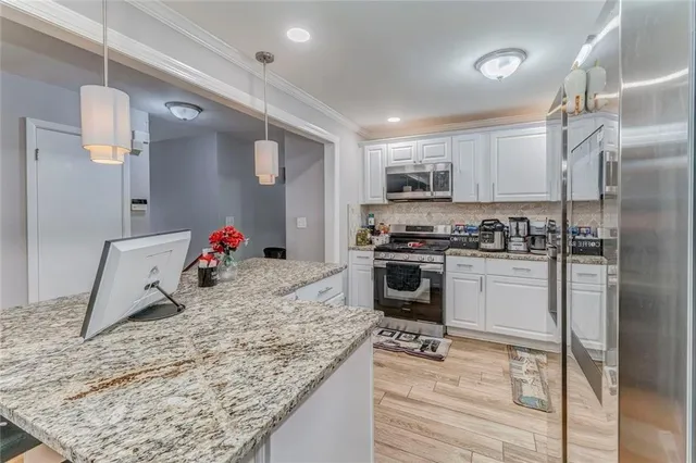 a kitchen with white cabinets and appliances
