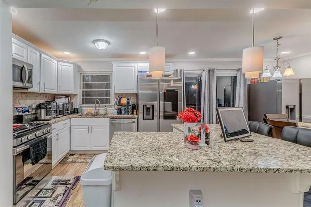 a kitchen view with counter top space a sink stainless steel appliances and cabinets