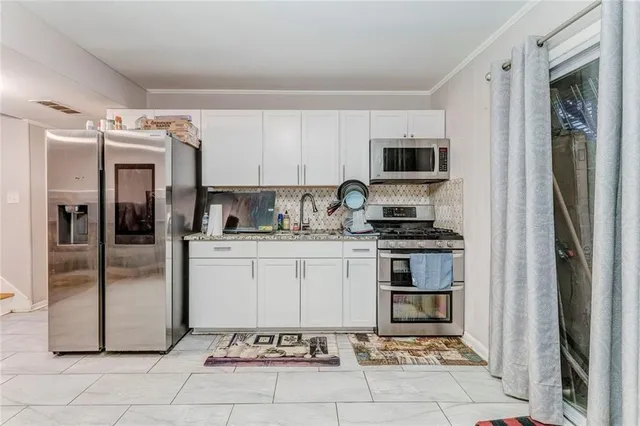 a kitchen with a refrigerator a microwave and cabinets