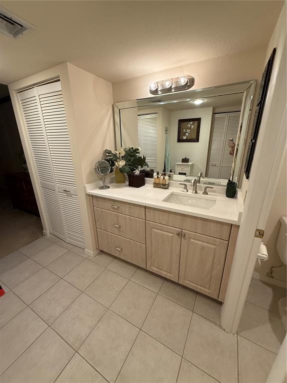1 Key Capri, Unit 502E Treasure Island, FL 33706 - Photo 21 of 51 a bathroom with a sink a toilet and mirror
