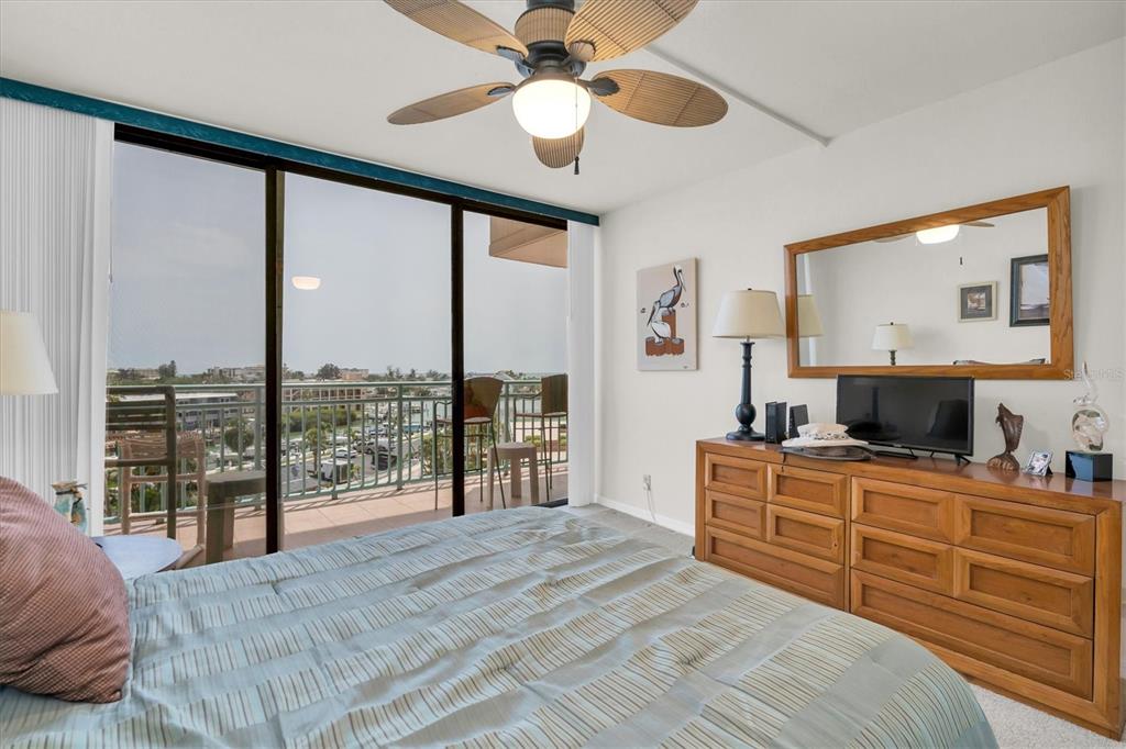 1 Key Capri, Unit 502E Treasure Island, FL 33706 - Photo 22 of 51 a bedroom with a large bed and a flat tv screen