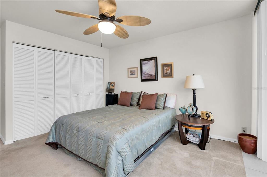 1 Key Capri, Unit 502E Treasure Island, FL 33706 - Photo 23 of 51 a bedroom with a bed and a chandelier
