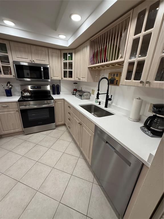 1 Key Capri, Unit 502E Treasure Island, FL 33706 - Photo 7 of 51 a kitchen with stainless steel appliances granite countertop a sink and a stove