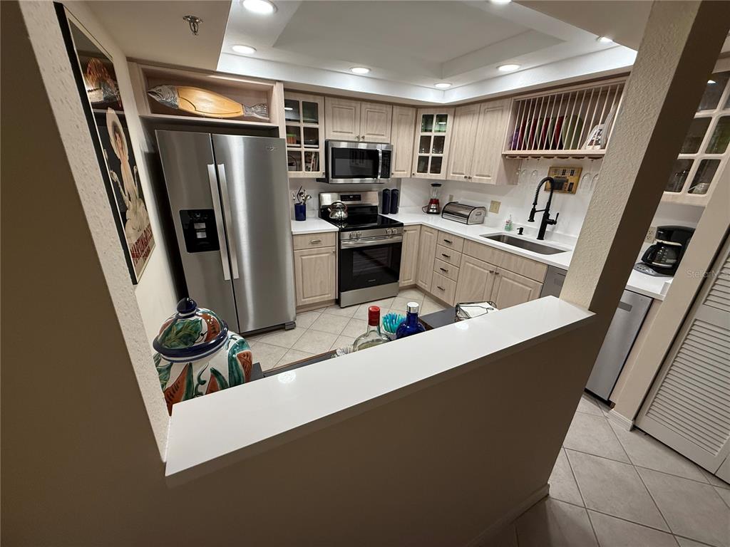1 Key Capri, Unit 502E Treasure Island, FL 33706 - Photo 8 of 51 a kitchen with refrigerator and white cabinets