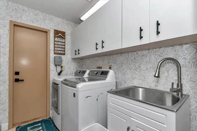 a view of a white house with a big yard and large trees