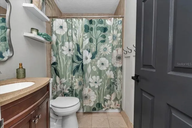 a view of a house with a yard and large trees