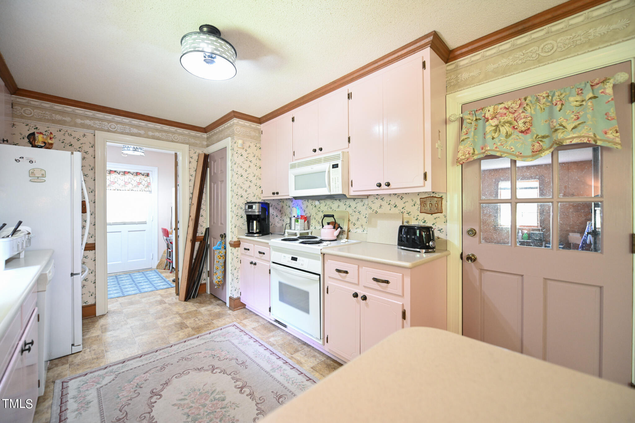 7254 Springfield School Road Lucama, NC 27851 - Photo 24 of 54 a large white kitchen with a stove a refrigerator a sink dishwasher and white cabinets with wooden floor