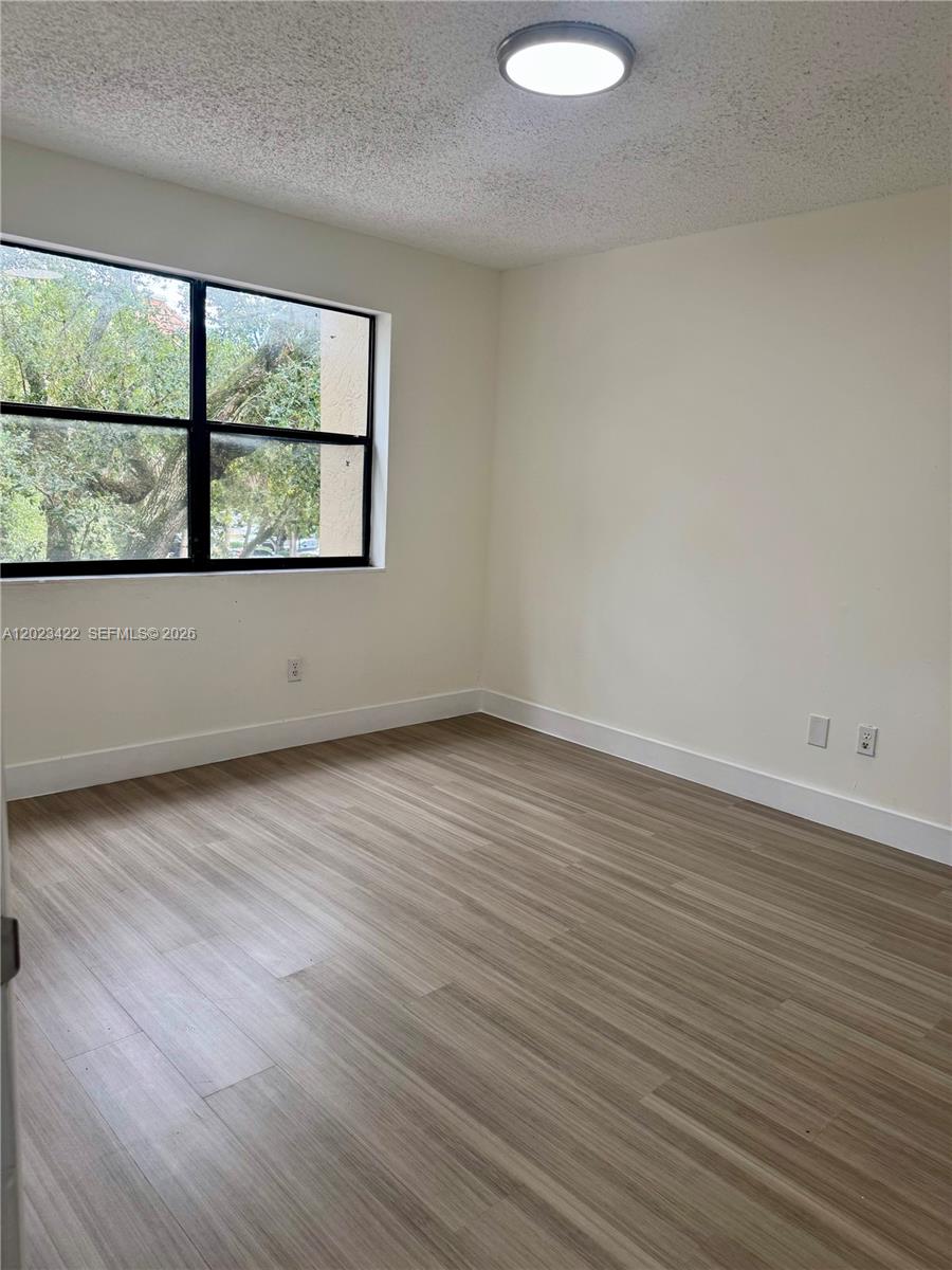 605 Ives Dairy Road, Unit 3067 Miami, FL 33179 - Photo 16 of 28 an empty room with wooden floor and windows