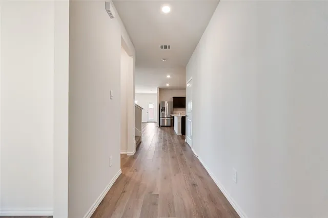 a view of a hallway with wooden floor and staircase