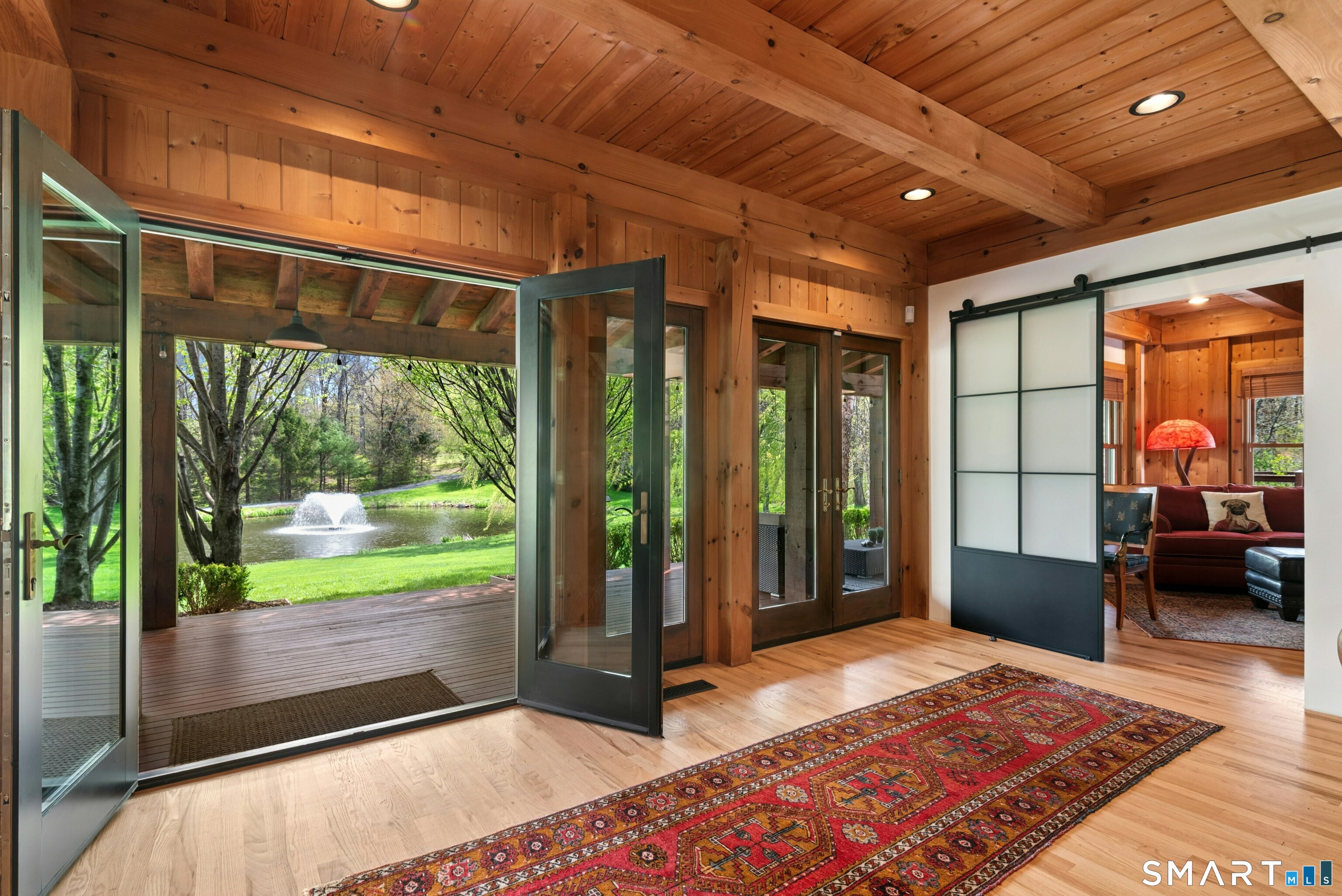 15 Silversmith Lane Redding, CT 06896 - Photo 7 of 36 French doors that open to the 1200+sq ft wrap-around decking and with sweeping views of the landscape and pond.
