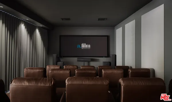 a projector room with a couch and a flat screen tv