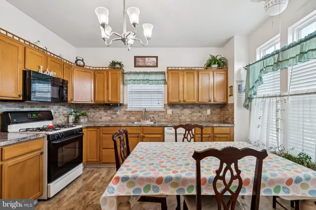 a kitchen with cabinets a sink stainless steel appliances and dining table
