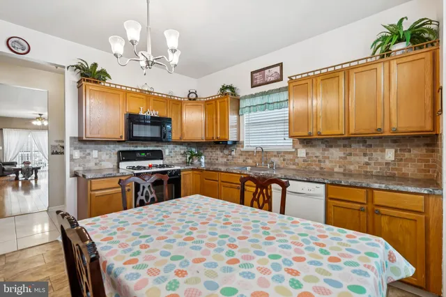 a kitchen with stainless steel appliances wooden cabinets granite counter tops and a refrigerator