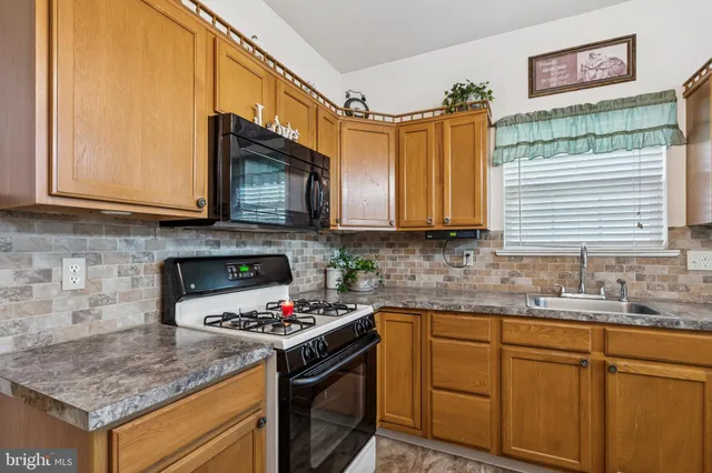 a kitchen with stainless steel appliances granite countertop a stove sink and cabinets