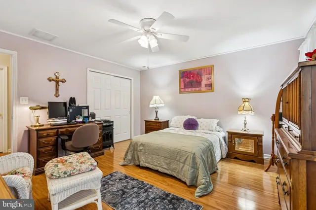 a bedroom with bed a flat tv screen and a dresser