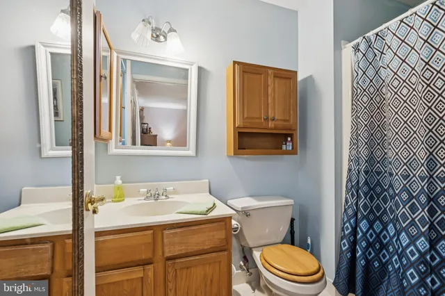 a bathroom with a granite countertop toilet sink and mirror