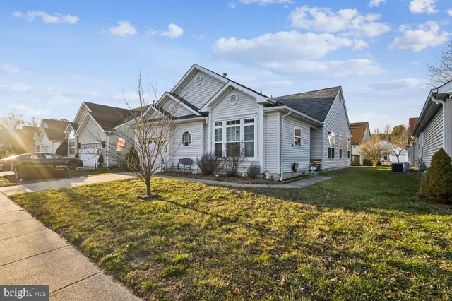 a view of a house with a big yard and large tree