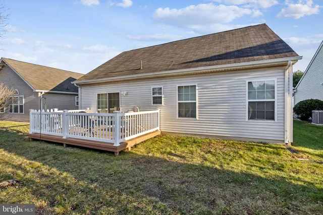 a view of a house with a yard and deck area