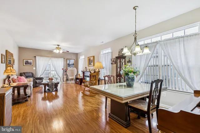 a view of a dining room and livingroom with furniture wooden floor a chandelier