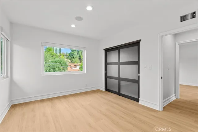 an empty room with windows and closet