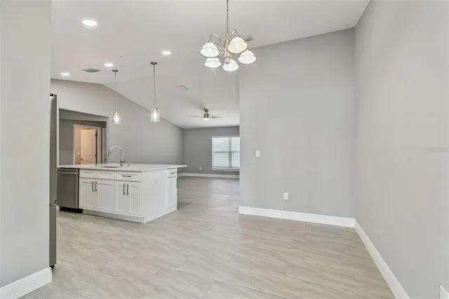 a view of a kitchen with refrigerator and wooden floor
