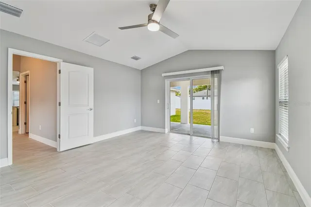 an empty room with wooden floor and ceiling fan